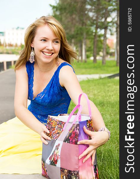 Pretty girl with a shopping bag in the park