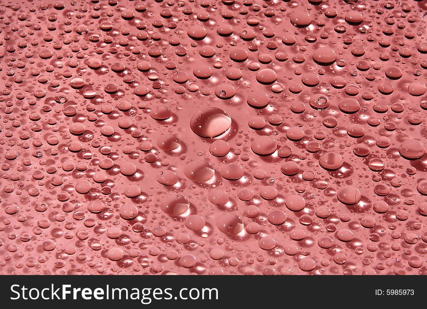 Drops of water on a red background in a view of the sun. Drops of water on a red background in a view of the sun