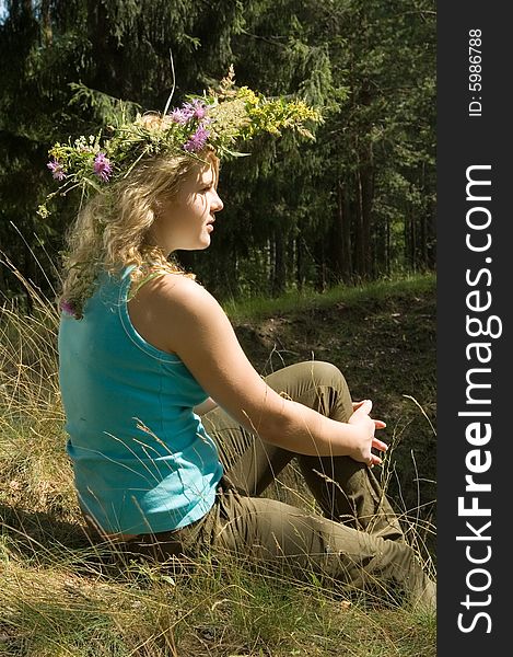Young beautiful blonde in a forest with flowers diadem. Young beautiful blonde in a forest with flowers diadem