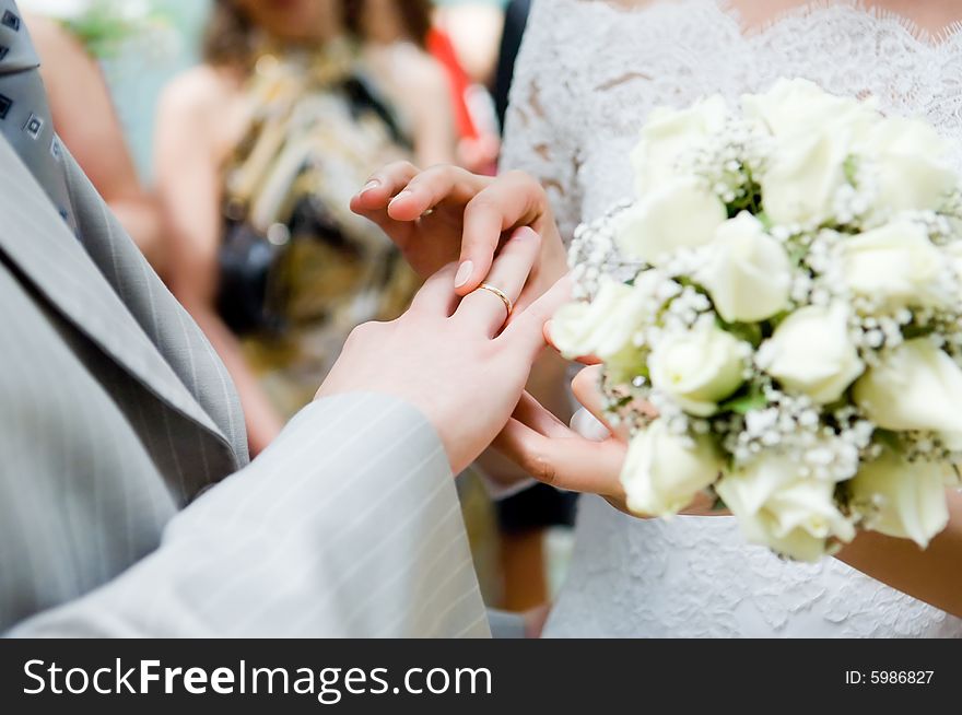 Close-up of newly-married putting on rings