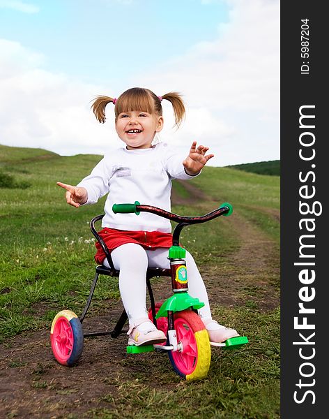 Happy little girl riding a bicycle outdoor