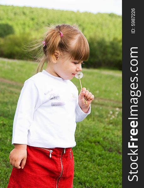 Girl blowing at the dandelion