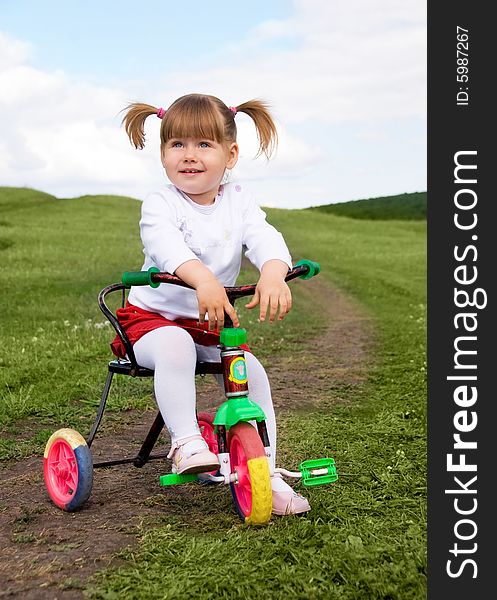 Dreamy little girl riding a bicycle outdoor