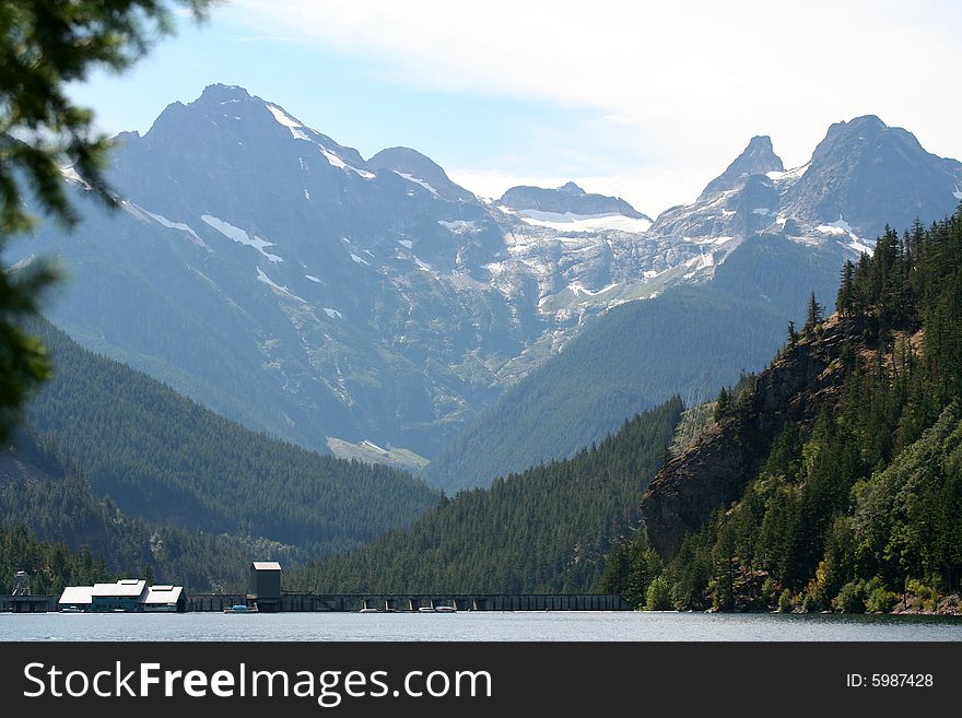 Mountain range framed by a valley with the top of a dam along the bottom. Mountain range framed by a valley with the top of a dam along the bottom