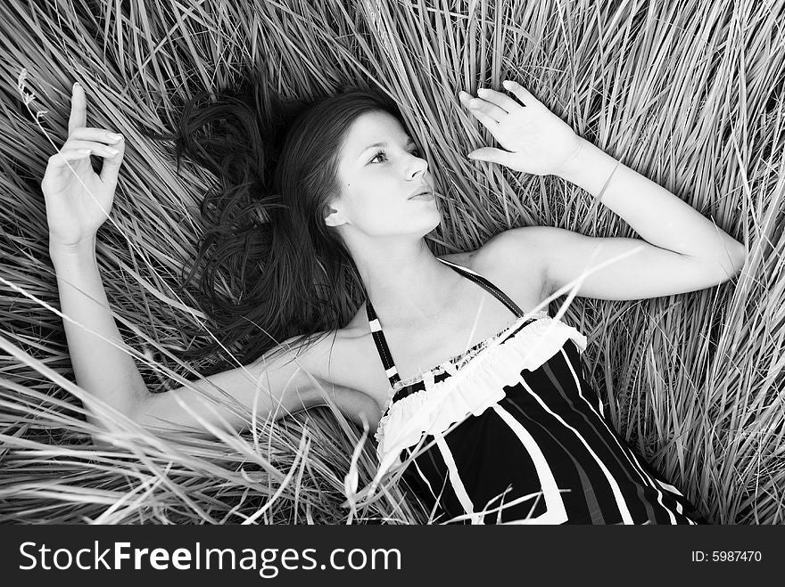 Lying beauty fashion woman on the black and white grass. Lying beauty fashion woman on the black and white grass