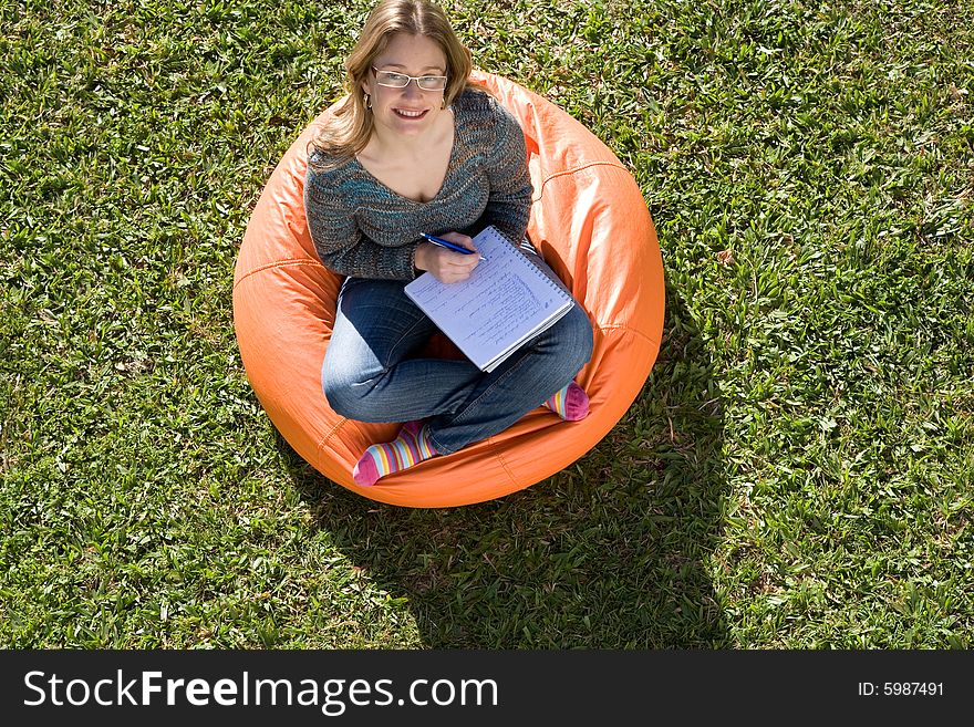 Beautiful woman working out sitting on orange puff