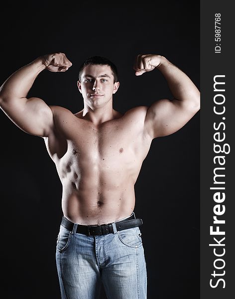 Young man athlete with perfect body at black background. Young man athlete with perfect body at black background