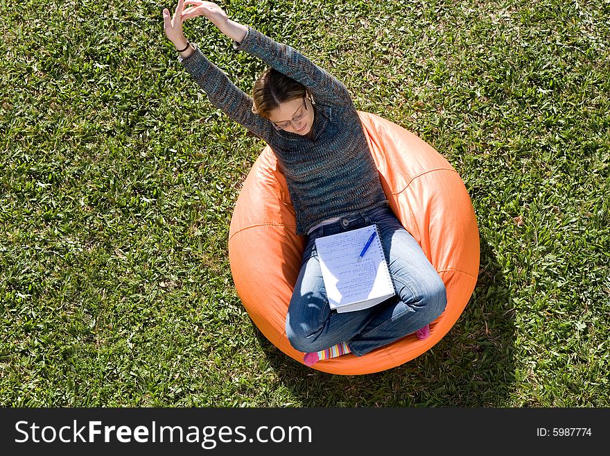 Beautiful woman working out sitting on orange puff