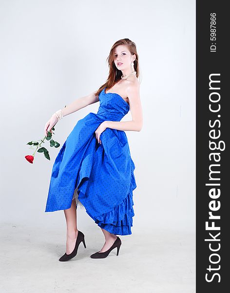 Beauty young woman in blue dress with rose at white isolated background