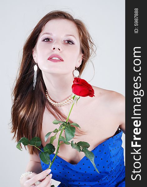 Beauty young woman in blue dress with rose at white isolated background