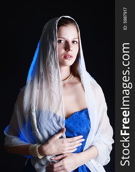 Beauty young woman in blue dress at black background