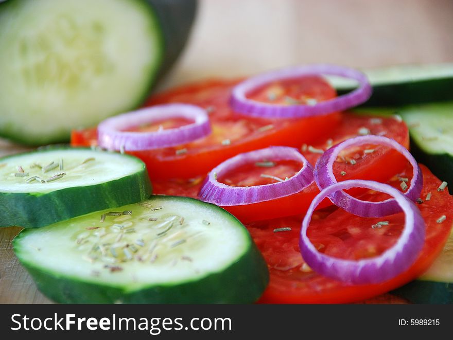 A detail of a fresh salad with onion,tomatoes and cucumber