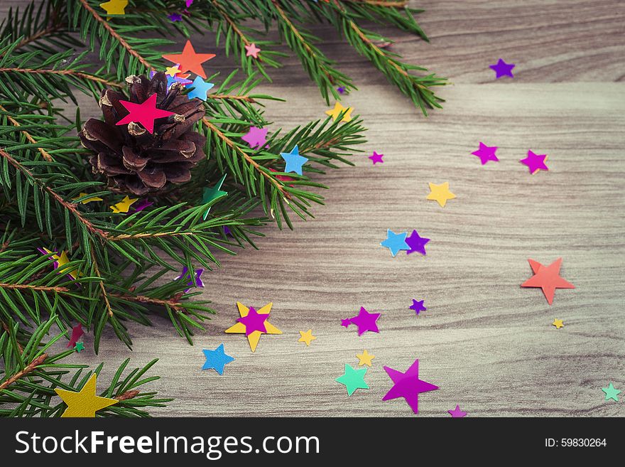 Spruce branches with festive decoration on the wooden background