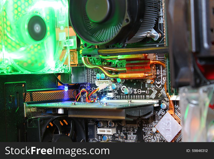 A close up of a computer mainboard with a green fan in the background. A close up of a computer mainboard with a green fan in the background.