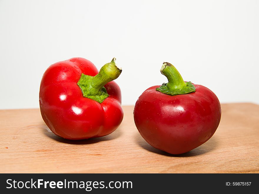 Two Ripe Red Peppers On Over White