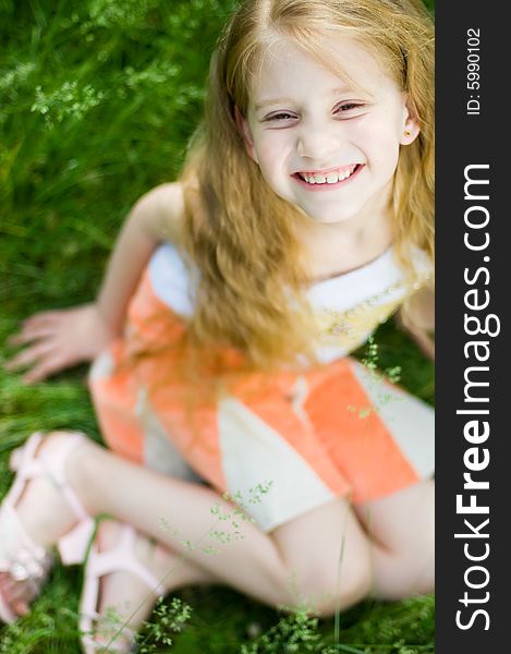 Smiling cute little girl outside in green grass, focus on face. Smiling cute little girl outside in green grass, focus on face