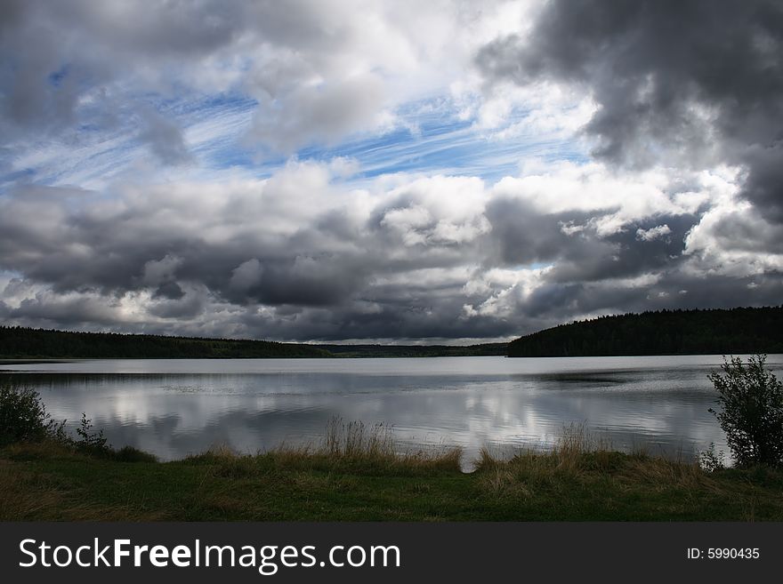 Pond under heavy grey clouds. Pond under heavy grey clouds