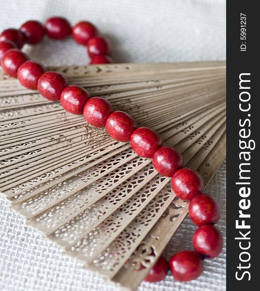 Red wooden beads on a wooden fan. Red wooden beads on a wooden fan