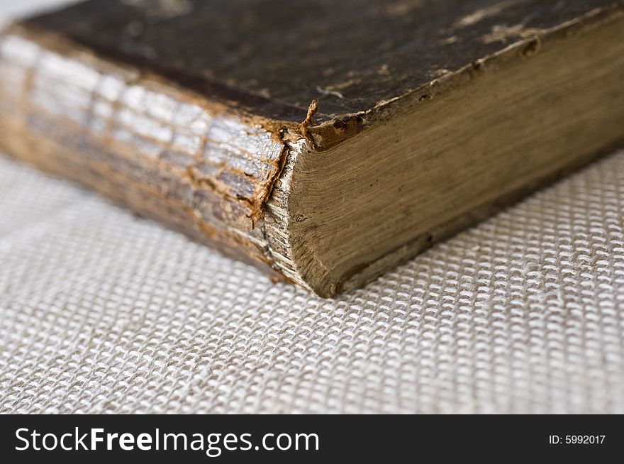 Old book in a brown cover on by a tissue background