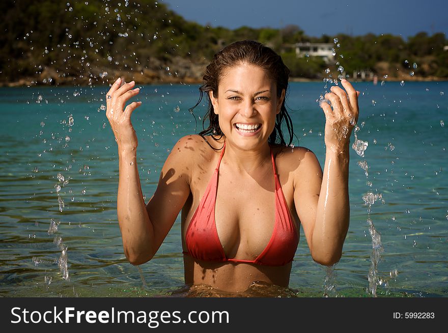 Beautiful young woman on a beach, splashing water. Beautiful young woman on a beach, splashing water.