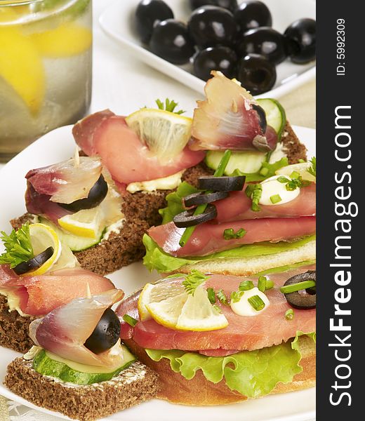 Delicious canapÃ©s with smoked salmon, olive, cucumber and fresh salad. Delicious canapÃ©s with smoked salmon, olive, cucumber and fresh salad