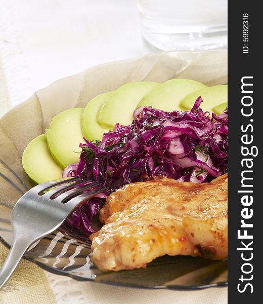 Pork steak with cabbage and sliced avocado