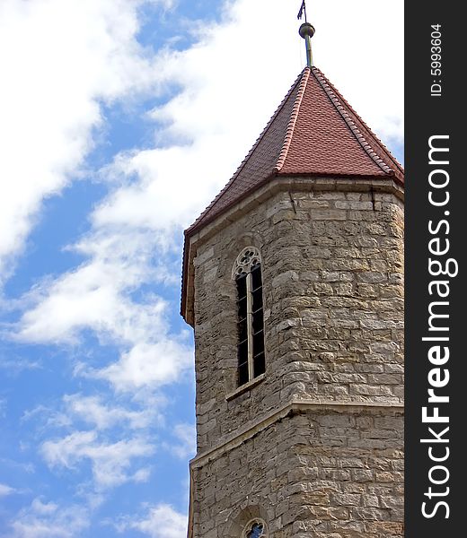 Historical church tower close up. The stone tower on background of the blue sky. Historical church tower close up. The stone tower on background of the blue sky.