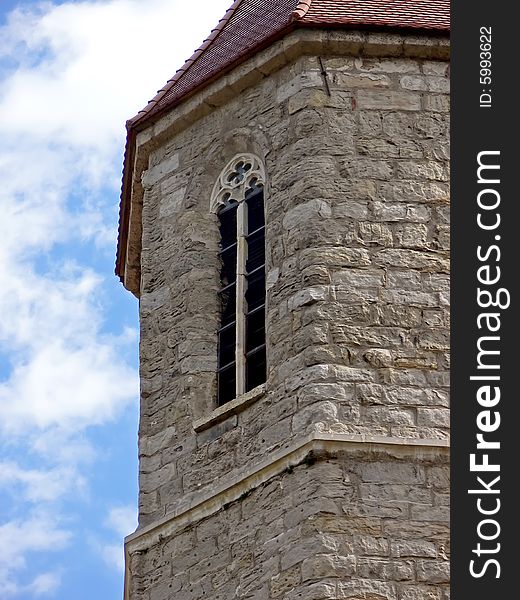 Historical church tower close up. The stone tower on background of the blue sky. Historical church tower close up. The stone tower on background of the blue sky.