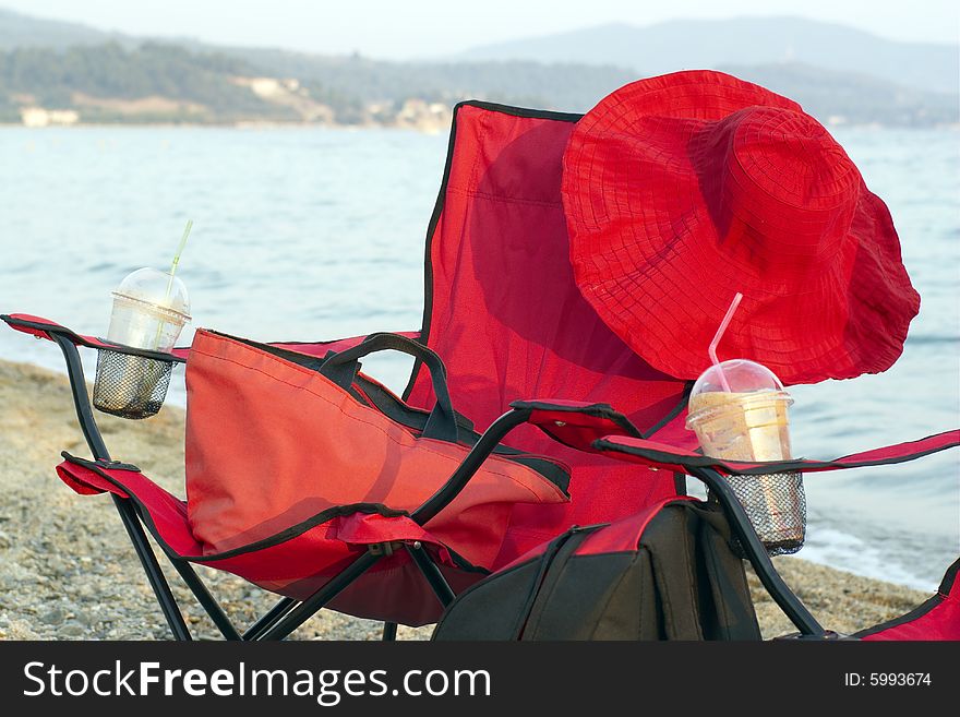 The red chairs on the beach with red hat. The red chairs on the beach with red hat