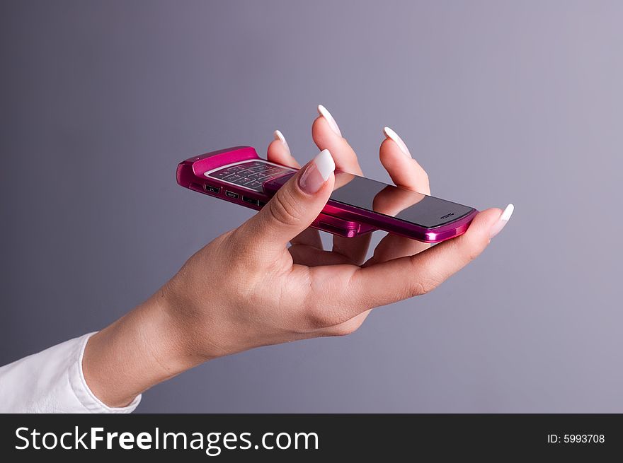 Female hand holding a pink mobile phone