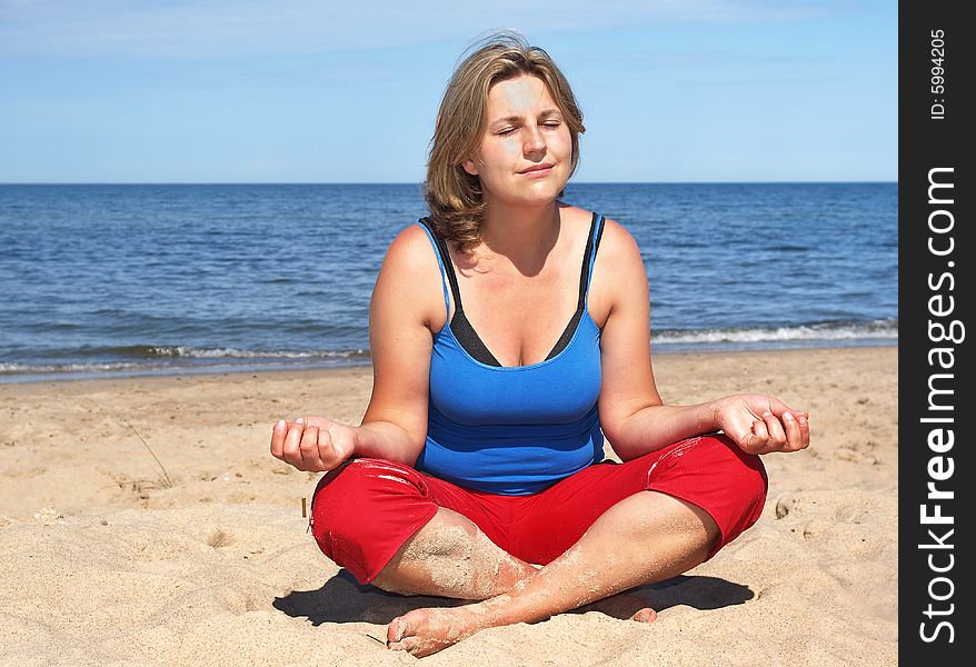 Woman is training yoga on the beach
