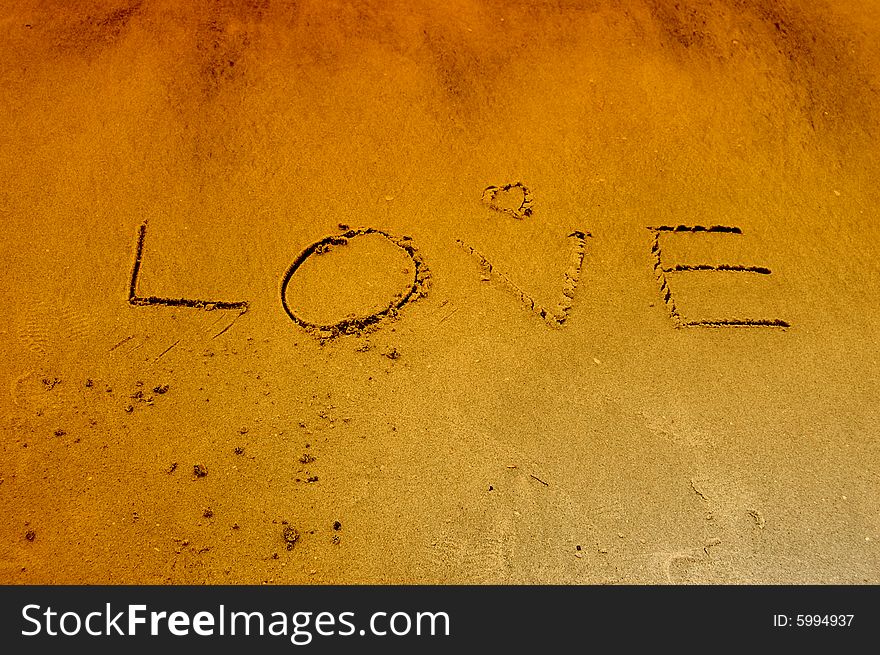 The word love written on the sand at the beach