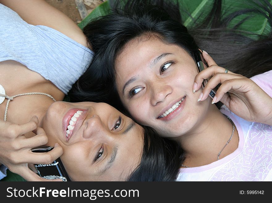 Two girl lie down on banana leaf and calling. Two girl lie down on banana leaf and calling