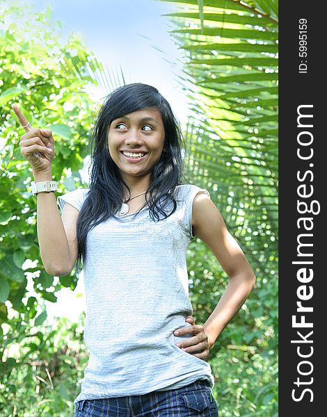 Girl pointing right outdoor and smiling