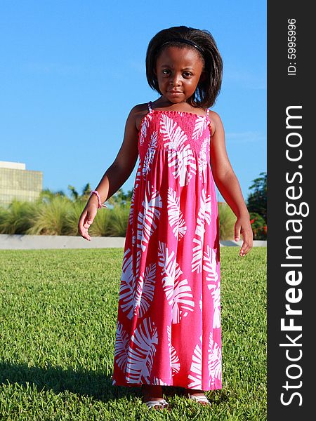 Young child standing on green grass looking at the camera. Young child standing on green grass looking at the camera.