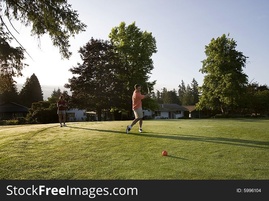 Couple Playing Golf On Course - Horizontal