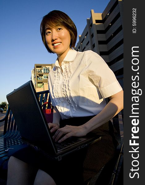 Smiling Woman Works On Laptop - Vertical