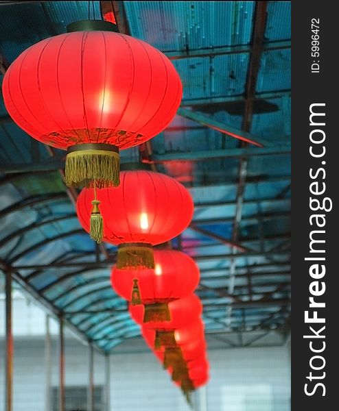 Red lantern, shining, typical Chinese decorations for new year. Hanged under the blue roof.