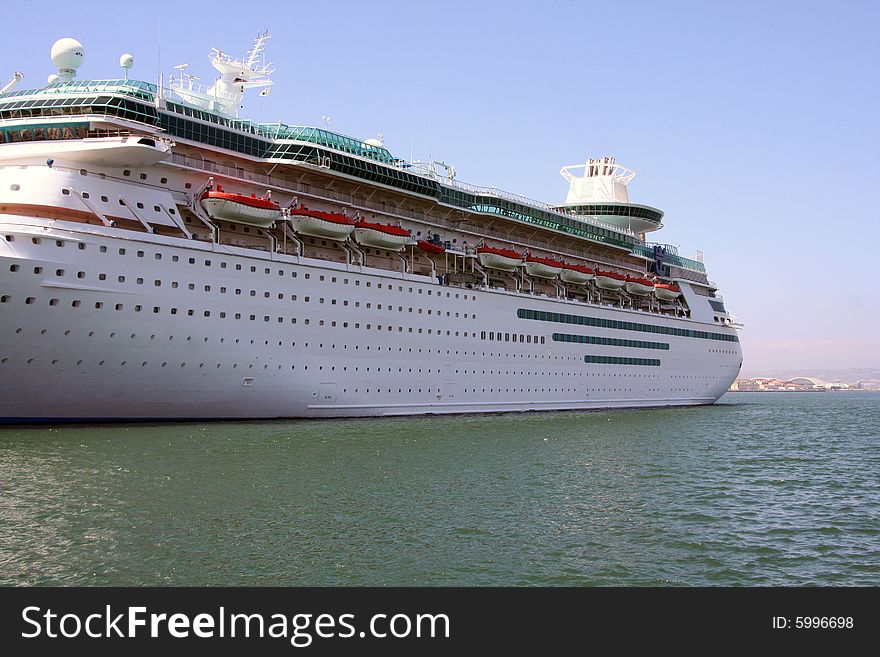 A big, older cruise ship is docked at the bay in San Diego, California.