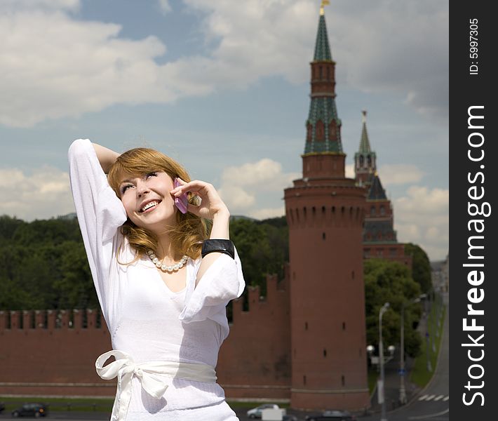 A photo of beautiful woman talking on the phone in Moscow near the Kremlin. A photo of beautiful woman talking on the phone in Moscow near the Kremlin