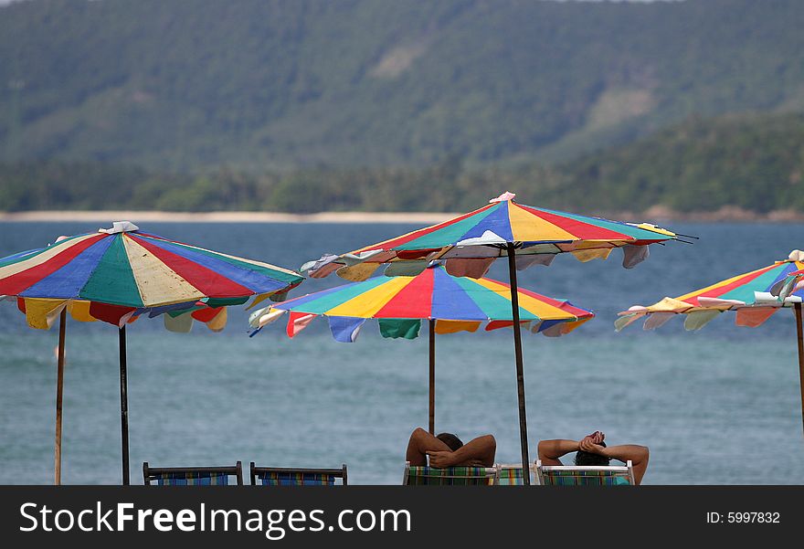 Colorfully sun beds and umbrellas in an island. Colorfully sun beds and umbrellas in an island