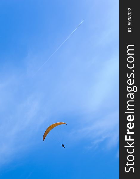 Man parachuting in blue sky. Man parachuting in blue sky