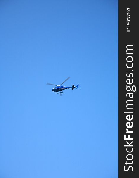 Blue helicopter flying at the blue sky of Canary Islands spain