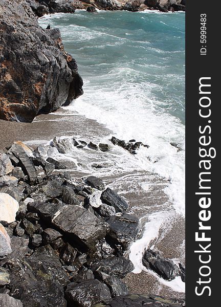 Waves rolling into the rocks in La Herradura bay on the Costa Tropical of Granada in Spain. Waves rolling into the rocks in La Herradura bay on the Costa Tropical of Granada in Spain.