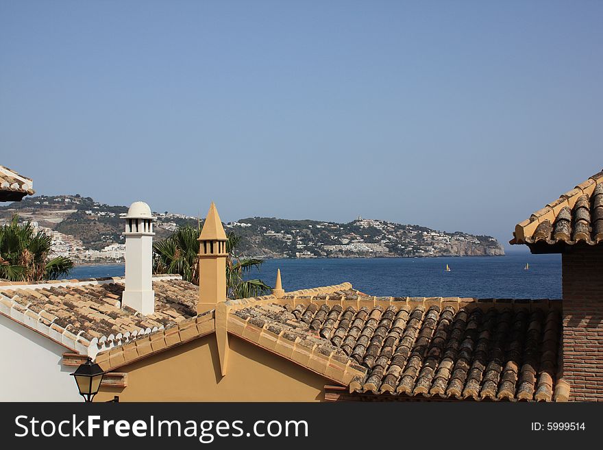 View of La Herradura bay on the Costa Tropical of Granada in Spain over the rooftops of a nearby urbanization. View of La Herradura bay on the Costa Tropical of Granada in Spain over the rooftops of a nearby urbanization.