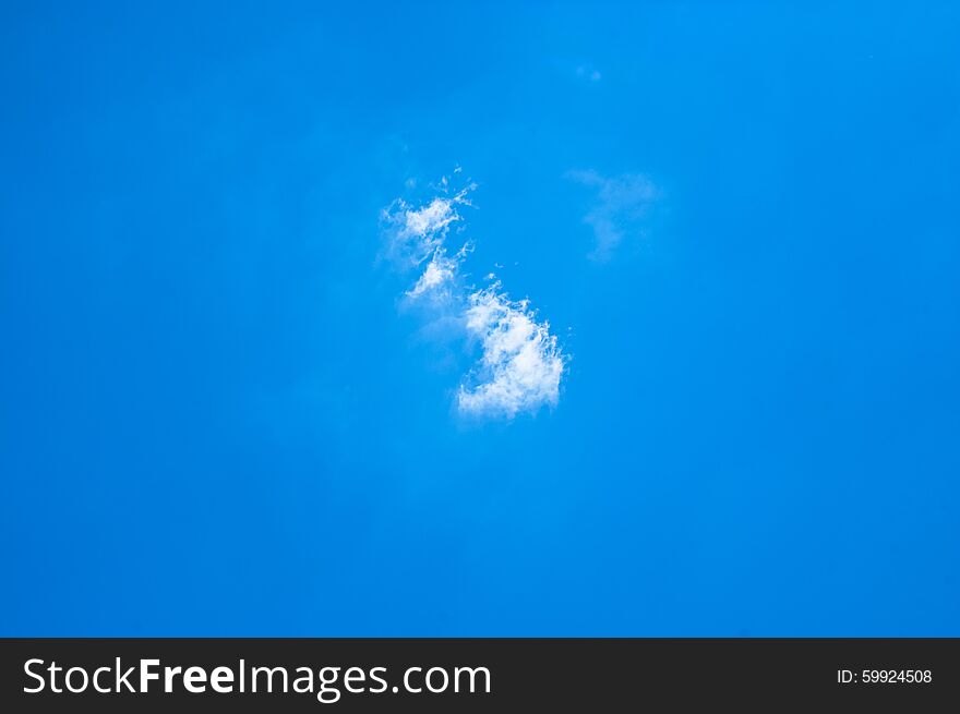 Small white clouds on light blue clear sky