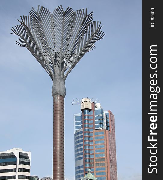 A large metal palm tree in Wellington's city square. Part of the skyline can be seen in the background.