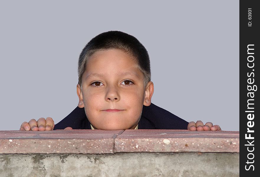 Boy hiding behind the fence. Boy hiding behind the fence