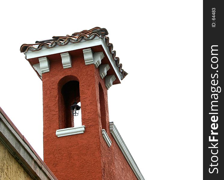 Details of tower with tile roof on terra cotta Spanish building, white trim, in the tropics