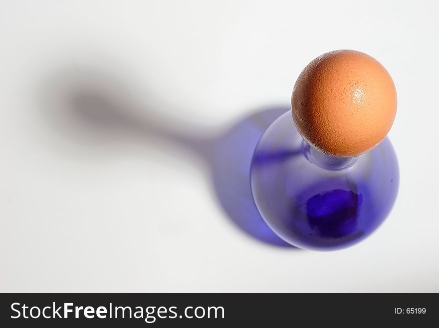 Brown egg capping a blue bottle. Brown egg capping a blue bottle